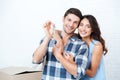 Couple showing keys to new home hugging looking at camera Royalty Free Stock Photo