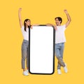 Couple showing white empty smartphone screen and gesturing yes Royalty Free Stock Photo