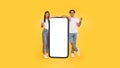 Couple showing white empty smartphone screen and gesturing yes Royalty Free Stock Photo