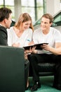 Couple signing sales contract at car dealer Royalty Free Stock Photo