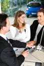 Couple signing sales contract at car dealer Royalty Free Stock Photo