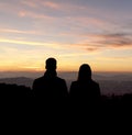 Couple silhouette looking to golden hour sky