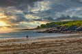 Couple in silhouette walking along the beach at sunset. Royalty Free Stock Photo