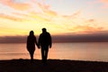 Couple silhouettes walking together at sunset Royalty Free Stock Photo
