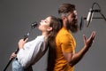 Couple singing. Singing man and girl in a recording studio. Expressive couple with microphone. Karaoke signer, musical Royalty Free Stock Photo