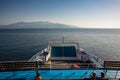 A couple and a single woman sitting on a ferry boat`s deck on the open sea on a summer day, a seagull flying above, Royalty Free Stock Photo