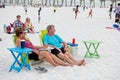 A couple sit in chairs on the beach while enjoying a summer concert at Pensacola Beach, Florida