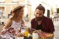 Couple sit reading guidebook outside a cafe, Ibiza, Spain