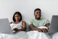 Couple Working on Laptops While Relaxing in Bed During a Cozy Indoor Evening Royalty Free Stock Photo