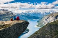 Couple sitting against amazing nature view on the way to Trolltunga. Location: Scandinavian