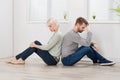 Couple Sitting Back To Back On Floor Royalty Free Stock Photo