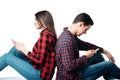 Couple sitting back to back and using phones Royalty Free Stock Photo