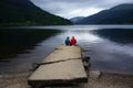 Couple sitting backward looking toward the Loch Lochy freshwater loch and the mountains in Scotland Royalty Free Stock Photo