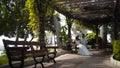 Couple sitting on bench in beautiful gazebo. Action. Beautiful couple sitting in gazebo in honeymoon. Husband kisses his