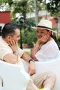 Couple sitting on a bench confidant chairs in Merida in Yucatan Mexico show their love with flirtatious looks and kisses