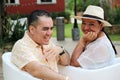 Couple sitting on a bench confidant chairs in Merida in Yucatan Mexico show their love with flirtatious looks and kisses