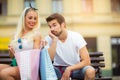 Couple sitting on a bench and holding shopping bags Royalty Free Stock Photo