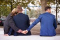 Couple hugging while the woman holding hands with another man