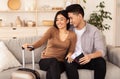 Couple Sitting With Boarding Pass Waiting For Vacation At Home