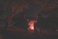 Couple sitting at burning camp fire in the night. Camping in the forest under starry sky, Namibia, Africa. Summer adventures and Royalty Free Stock Photo