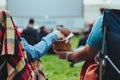 couple sitting in camp-chairs in city park looking movie outdoors at open air cinema