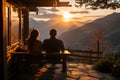 A couple sitting in chairs watching the sunset over mountains Royalty Free Stock Photo