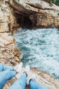 couple sitting at cliff looking at storming sea near grotto Royalty Free Stock Photo