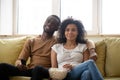 Couple sitting on couch eating popcorn watching movies on TV Royalty Free Stock Photo