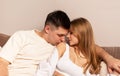 Couple sitting on couch. Handsome man kissing wife or girlfriend on shoulder. Passion, love, intimacy concept. Home date Royalty Free Stock Photo