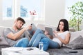 Couple sitting on a couch with tablet computers