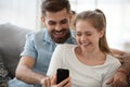 Couple sitting on couch using mobile phone Royalty Free Stock Photo