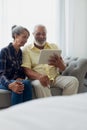 Couple sitting on couch while using a tablet Royalty Free Stock Photo