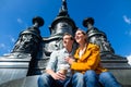 Couple sitting in Dresden Theaterplatz on statue