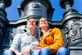 Couple sitting in Dresden Theaterplatz on statue