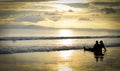 Couple Sitting enjoying beautiful golden sunset on a Beach Royalty Free Stock Photo