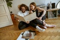 Young couple sitting on floor and listening music on vinyl player with different vinyl records Royalty Free Stock Photo