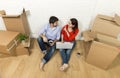 couple sitting on floor moving in new house choosing furniture with computer laptop Royalty Free Stock Photo