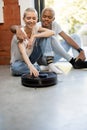 Couple sitting on floor with robot vacuum cleaner