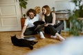 Couple sitting on floor and stroking cats while listening music on vinyl player with records Royalty Free Stock Photo