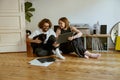 Couple sitting on floor and stroking cats while listening music on vinyl player with records Royalty Free Stock Photo