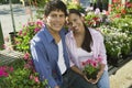 Couple Sitting Among flowers at plant nursery portrait Royalty Free Stock Photo