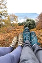 Couple sitting in the forest, only the feet and shoes are visible. Unrecognizable persons