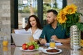 Couple is sitting in front of the laptop on terrace