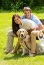 Couple sitting with golden retriever in park Royalty Free Stock Photo