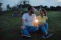 Couple sitting on grass in the evening park. Royalty Free Stock Photo