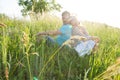 Couple sitting on green grass in the sun shine ray. Man and woman on ground in grass looking each other over shoulders Royalty Free Stock Photo