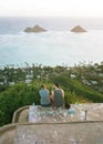 Couple sitting at Lanikai Pillbox with the view of the Mokulua islands in the background Royalty Free Stock Photo