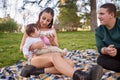 couple sitting on the floor while the mother feeds her baby Royalty Free Stock Photo