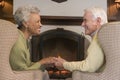 Couple sitting in living room by fireplace