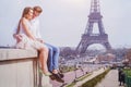 Couple sitting near Eiffel Tower in Paris, honeymoon in Europe